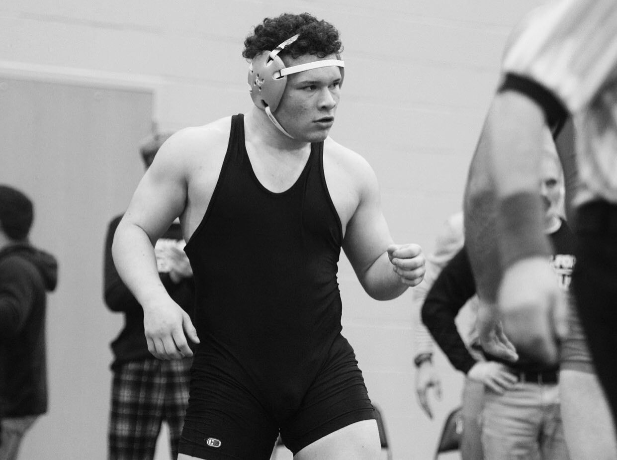 Louie wearing wrestling headgear and preparing to compete